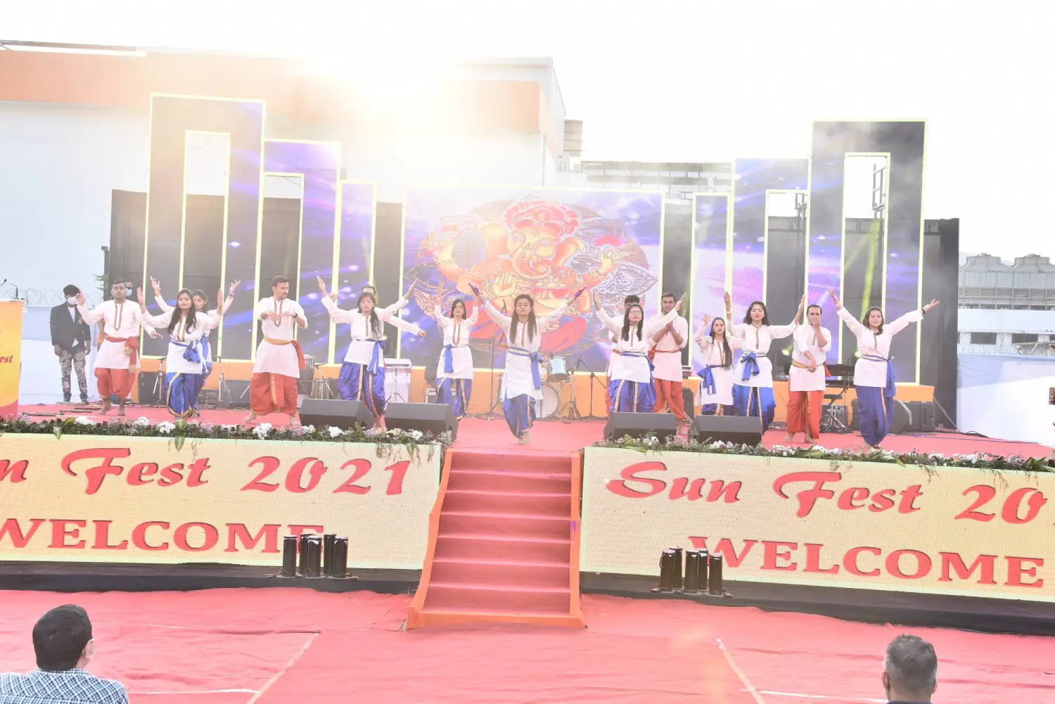 Musical performance on stage with three performers and ITT banner in background